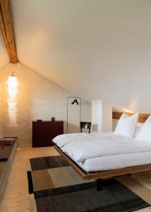 a bedroom with a large white bed and a table at Altstadthaus - neu renoviert, barrierefrei in Murten