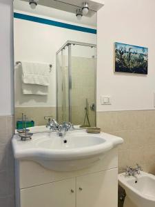 uma casa de banho branca com um lavatório e um chuveiro em Miralago Casa Vacanze em Riva di Solto