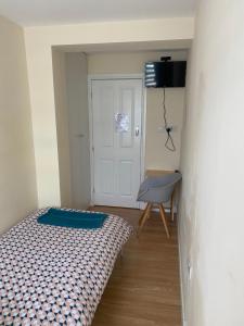 um pequeno quarto com uma cama e uma cadeira em Single Room only for one adult em Southall