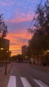 an empty street with a sunset in a city at Habitación privada in Valencia