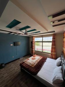 ein Schlafzimmer mit großem Bett und Fenster in der Unterkunft Royal Resort Skardu in Skardu