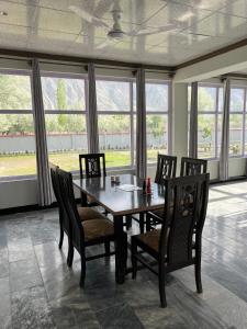 a dining room with a wooden table and chairs at Royal Resort Skardu in Skardu