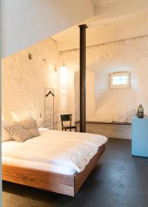 a bedroom with a large bed in a brick wall at Altstadthaus - neu renoviert, barrierefrei in Murten