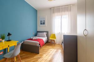 1 dormitorio con cama y escritorio amarillo en [Casa Graziola] Wi-Fi, Netflix, 5* Comfort, en Gaggiano