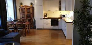 una cocina con armarios blancos y una mesa con sillas. en Leilighet sentralt i Trondheim en Trondheim