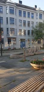 a large white building with windows and a bowl of flowers at Leilighet sentralt i Trondheim in Trondheim