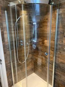 La salle de bains est pourvue d'une douche avec une porte en verre. dans l'établissement Four Bedroom modern Victorian Wandsworth House, à Londres