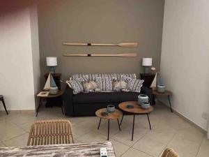 a living room with a black couch and tables at La Torretta Nettuno in Nettuno
