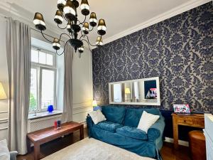 salon z niebieską kanapą i lustrem w obiekcie DECOR metro WiFi 300 Mbs 65TV Netflix HBO w Warszawie +37 zdjęć