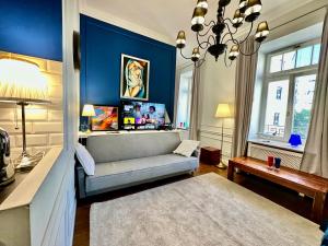 a living room with a couch and a blue wall at DECOR metro WiFi 300 Mbs 65TV Netflix HBO in Warsaw