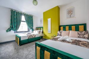 a bedroom with two beds and a yellow wall at *15w* setup for your most amazing & relaxed stay + Free Parking + Free Fast WiFi * in Beeston Hill