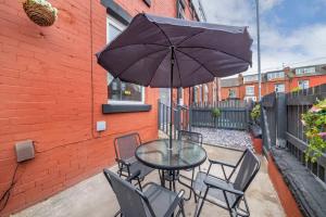 a table with chairs and an umbrella on a patio at *15w* setup for your most amazing & relaxed stay + Free Parking + Free Fast WiFi * in Beeston Hill