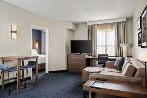 a hotel room with a couch and a bed at Residence Inn by Marriott Chicago Naperville/Warrenville in Warrenville