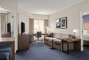a hotel room with a couch and a bed at Residence Inn by Marriott Chicago Naperville/Warrenville in Warrenville