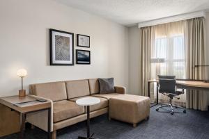 a living room with a couch and a desk at Residence Inn by Marriott Chicago Naperville/Warrenville in Warrenville