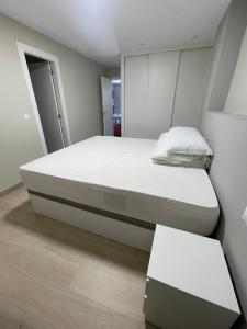 una camera da letto con un grande letto con materasso bianco di Apartamento Recién Reformado en Somo junto iglesia a Somo