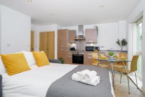 a bedroom with a large white bed and a table at Cosy Studio near Stratford, O2 and Canary Wharf in London