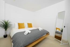 a bedroom with a bed with towels on it at Cosy Studio near Stratford, O2 and Canary Wharf in London
