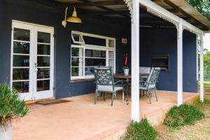 una casa azul con patio con mesa y sillas en The Knoll Historic Guest Farm, en Hilton