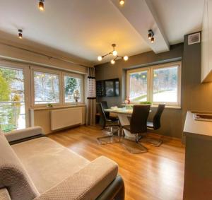 salon ze stołem i krzesłami w obiekcie Kurort Kozubnik Apartament 33 Wellness &SPA w mieście Porąbka