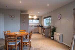 a kitchen and dining room with a table and chairs at Beachside Apartment in Hokitika