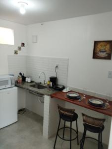 cocina con 2 taburetes y encimera en Vaccani Apart en Macaé