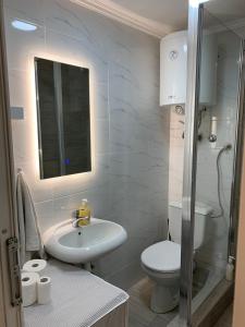 a bathroom with a sink and a toilet and a mirror at LUX BANOVO BRDO apartman in Belgrade
