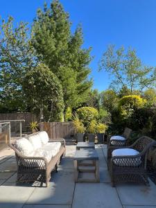 eine Terrasse mit 2 Korbstühlen und einem Tisch in der Unterkunft WM Garden Cottage in Edinburgh