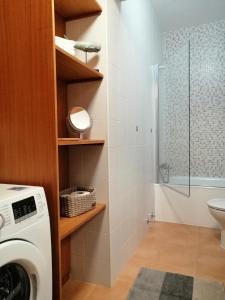 a bathroom with a washing machine and a shower at Apartamento Avenida - AL 1798 in Horta