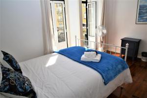 1 dormitorio con 1 cama con manta azul y ventana en Wonderful suite, en Lisboa