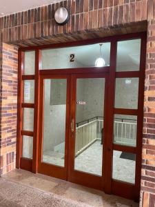 ein Backsteingebäude mit einer Doppeltür mit einem Fenster in der Unterkunft Apartamento Recién Reformado en Somo junto iglesia in Somo