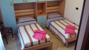 two beds in a room with pink towels on them at Casa Vacanze Faeto in Faeto