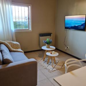 uma sala de estar com um sofá e uma televisão em Buona Vita Departamento Alto Dorrego - Mendoza em Guaymallén