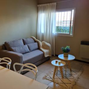 uma sala de estar com um sofá e mesas e uma janela em Buona Vita Departamento Alto Dorrego - Mendoza em Guaymallén