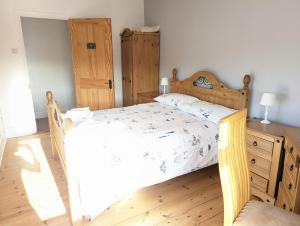 a bedroom with a wooden bed and a wooden dresser at Pipers Hill in Sidmouth