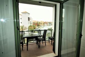 balcón con mesa y sillas y vistas a la calle en New view Sotogrande Marina - Jungla del Loro, en Sotogrande