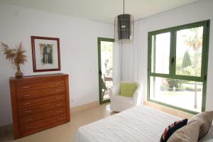 1 dormitorio con 1 cama, vestidor y silla en New view Sotogrande Marina - Jungla del Loro, en Sotogrande