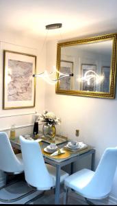 - une table à manger avec des chaises blanches et un miroir dans l'établissement Spacious one bedroom ft in Central London King’s Cross, à Londres