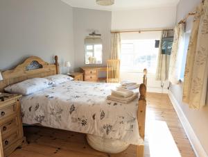 1 dormitorio con 1 cama y suelo de madera en Pipers Hill en Sidmouth
