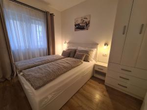 a bedroom with a large bed and a window at Apartman Zrno in Vodice