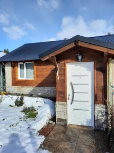 una casa con una puerta blanca en la nieve en Playa Serena en San Carlos de Bariloche