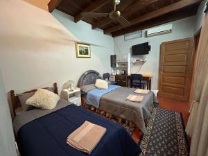 a room with two beds and a desk and a tv at Habitación en suite, Excelente Ubicación in Asuncion