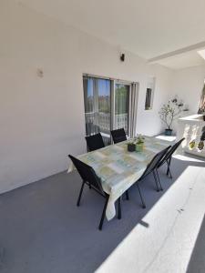 a dining room with a table and chairs and a window at Apartman Zrno in Vodice