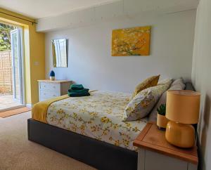 um quarto com uma cama e uma mesa com um candeeiro em Dove Apartments em Oxford