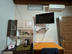 a room with a desk with a television and a table with a table sidx sidx at Habitación en suite, Excelente Ubicación in Asunción
