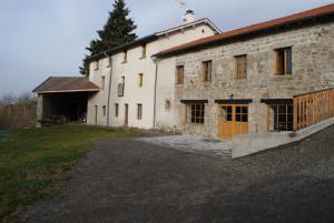 a large stone building with a large yard in front of it at Le Fournia in Grandrif