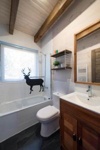 a bathroom with a sink toilet and a deer on the wall at Cabañas Vista a Corralco in Malalcahuello
