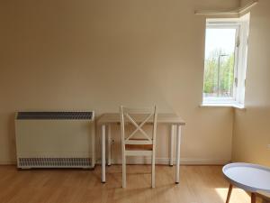 een tafel en stoel in een kamer met een raam bij Spacious Room in Leafy, Quiet N4 in Londen
