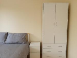 een slaapkamer met een grote witte kast naast een bed bij Spacious Room in Leafy, Quiet N4 in Londen