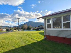 ein Haus an der Seite einer Straße mit einem Grasfeld in der Unterkunft Your Home in Rotorua 3 Frank Street in Rotorua